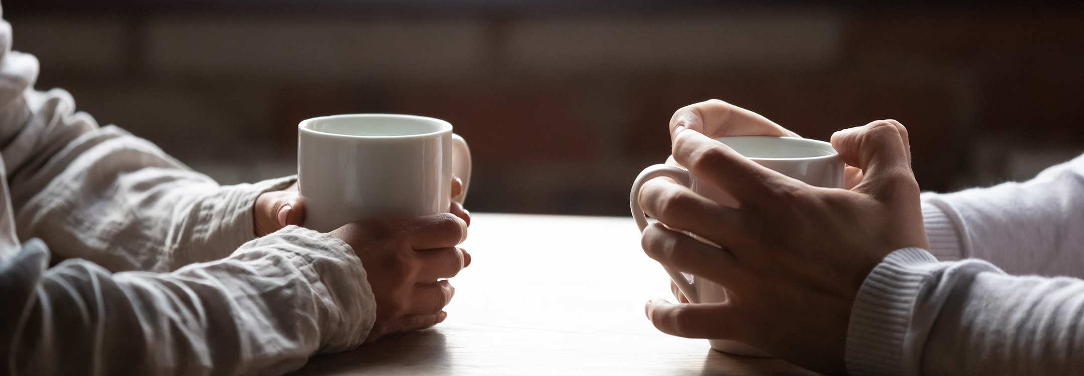 couple in café holding coffee cups