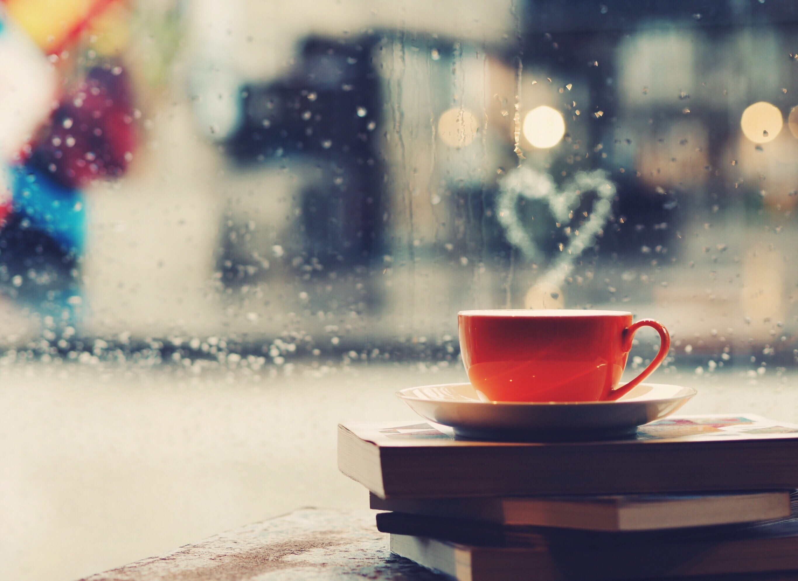 books and coffee at a window with rain