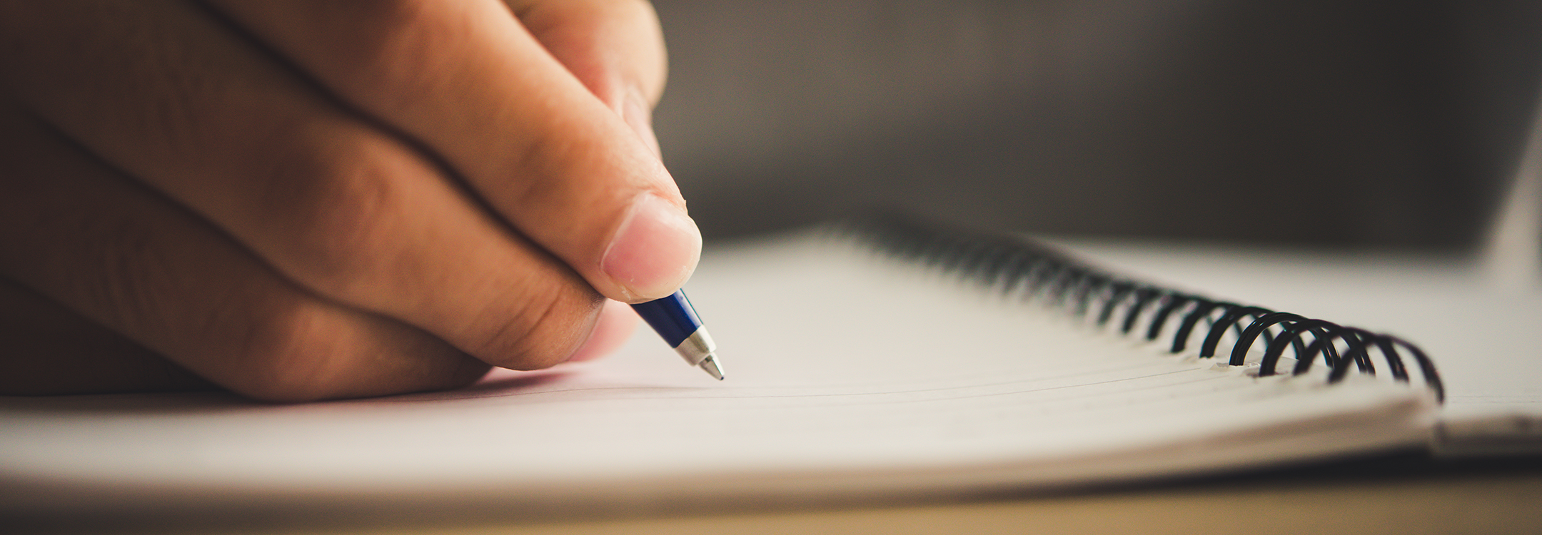 close up of a hand writing on notebook