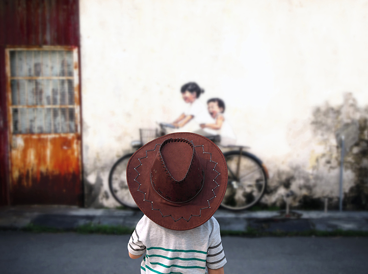 Kid looking at the street mural in George Town