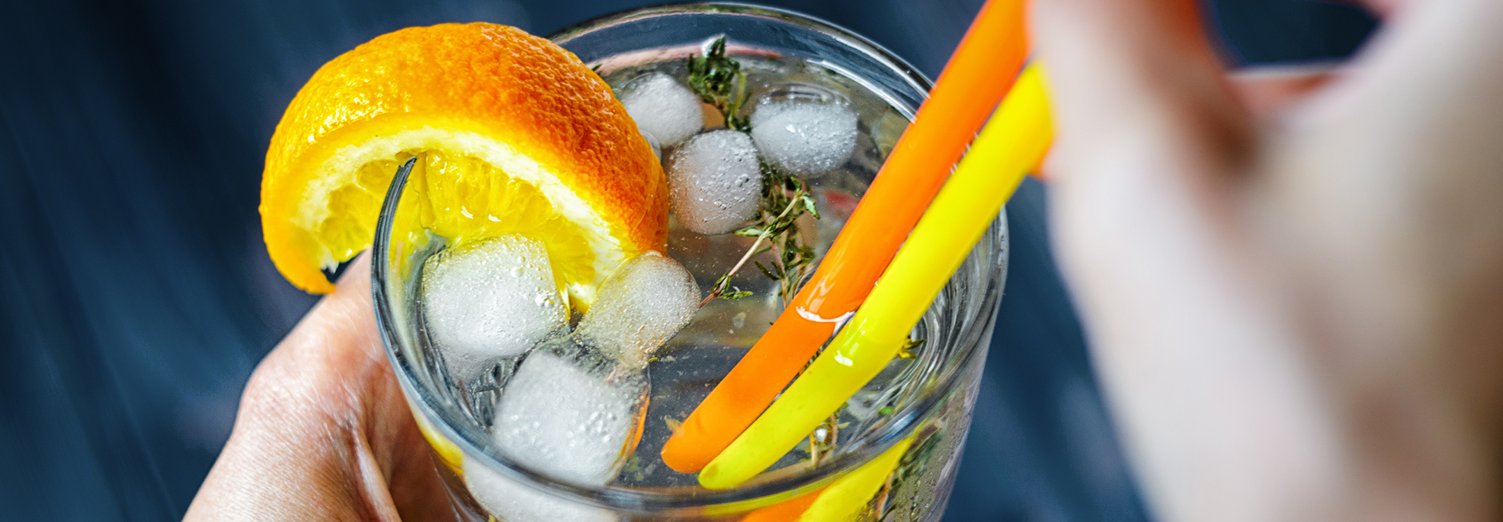 Gin mixed with tonic, and a slice of orange and rosemary